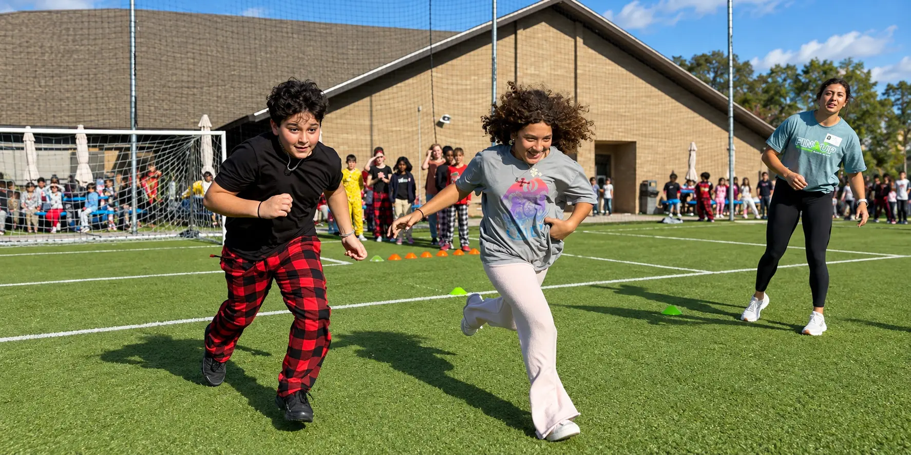 Two students racing across a school field alongside a Sharks athlete